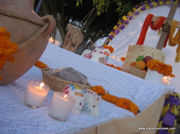 The display of a typical spread. You can see candles, food and sugar skulls.