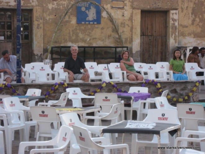 A couple us sitting on the white plastic chairs. We do like each other, we just like to spread out!