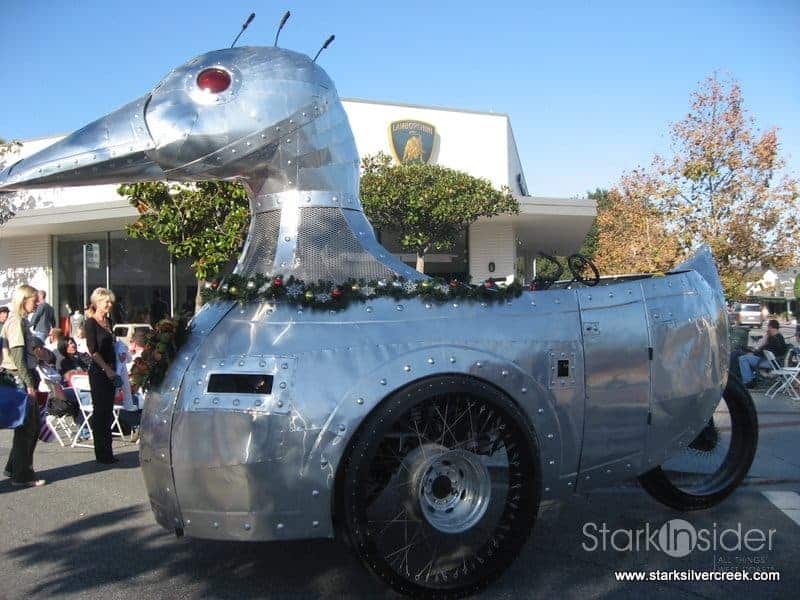 A giant aluminum duck on wheels attacks miniature Santas and cub scouts