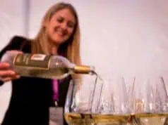 Woman pouring Sauvignon Blanc white wine into glass demonstrating proper French pronunciation