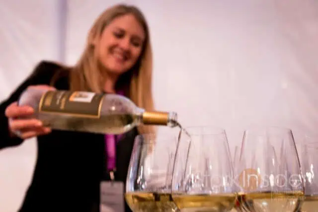 Woman pouring Sauvignon Blanc white wine into glass demonstrating proper French pronunciation