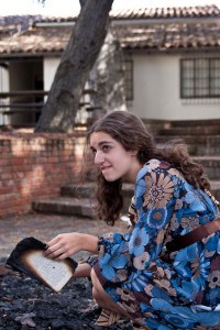 Clarisse (Jenny Dally) pensively strokes the burnt pages.