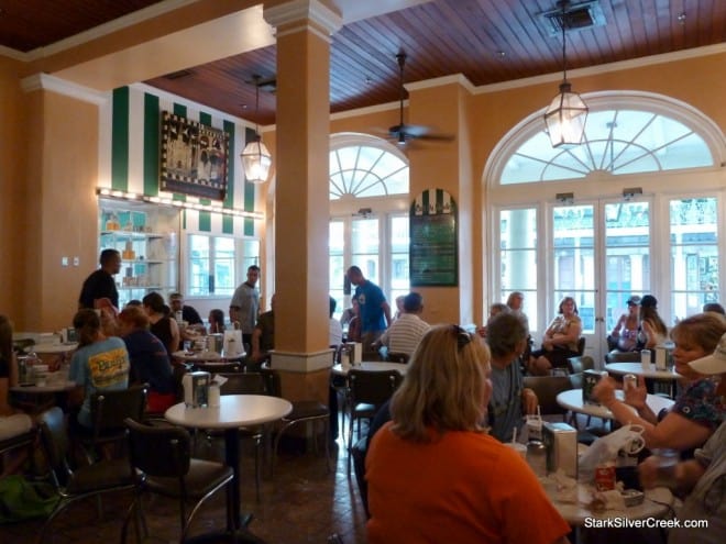 Indoor dining room at Café du Monde with round tables and guests