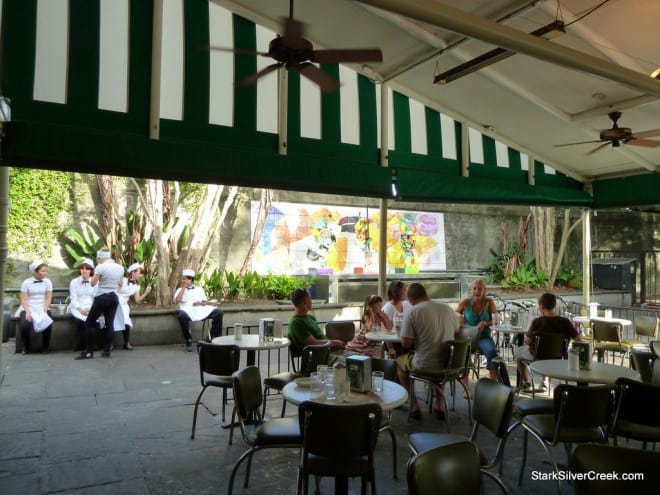 Outdoor seating area under green and white awning in New Orleans