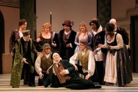 To earn his master’s sympathy (and get himself out of trouble), Scapin (Bill Irwin, front and center) pretends to be dying, as the cast looks on. Photo by Kevin Berne.