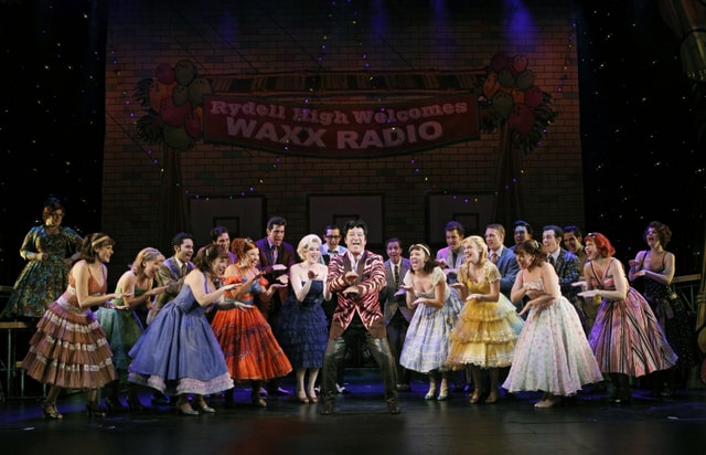 Eddie Mekka (center) as "Vince Fontaine" teaches the gang at Rydell High to do the “Hand Jive" in GREASE