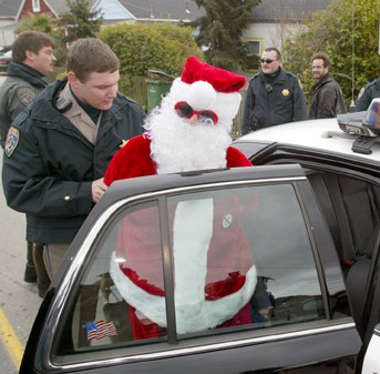 Wavy Gravy is placed in a CHP cruiser away from the gates of San Quentin Prison on Tuesday, February 3, 2004, by a California Highway Patrol officer after being arrested for trespassing and blocking the gates of the prison. (2004)