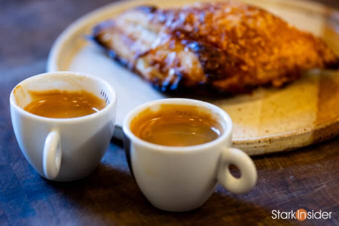 Two rich espresso shots ready to enjoy with a warm croissant-style pastry