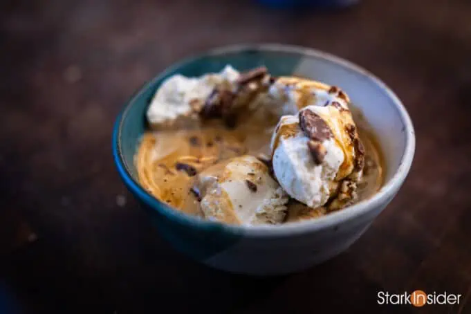 An Affogato ready to serve with Vanilla Bean ice cream. chocolate bits, maple syrup and a double shot of espresso.