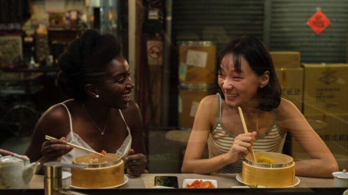 Aya and Cai share a quiet moment in a Chinese tea house — still from "Black Tea" (2024)