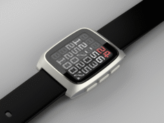 Pebble Time 2 smartwatch laying flat with black strap, showing a stylized segmented digital clock interface with a red number highlight.