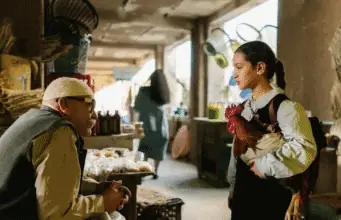 The President’s Cake — a haunting portrait of Iraq’s marshlands Scene from The President’s Cake — Lamia (Baneen Ahmad Neyyef) speaks with a vendor while holding a rooster in an Iraqi market.