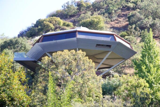 John Lautner’s Chemosphere house perched on a concrete column above the trees in the Hollywood Hills of Los Angeles, California.