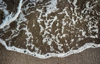 When the Summit Was Already Over: Third Mind Field Notes, Part III Loreto Bay written in sand being washed away by ocean wave - metaphor for ephemeral nature of human-AI collaboration summit